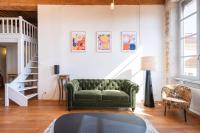 a living room with a green couch and a staircase at Le Cocon Pacôme Les Autres in Lyon