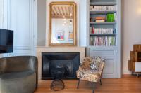 a living room with a chair and a mirror at Le Cocon Pacôme Les Autres in Lyon