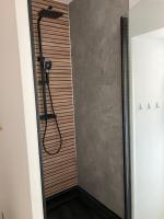 a shower in a bathroom with a wooden wall at T2 Le Conquet &quot;Molène&quot; avec parking privé 300m commerces in Le Conquet