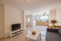 Una sala de estar con un sofá y un televisor. en Desert Pearl, en Beer Sheva