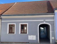 a white building with an archway and a red roof at Domeček Slavonice in Slavonice