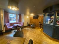 a restaurant with a bar and tables and chairs at Plas Coch Hotel Ltd in Bala
