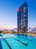 a swimming pool in front of a tall building at Sheraton Guangzhou Hotel in Guangzhou