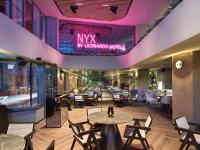 un restaurante con mesas y sillas y un escenario en NYX Hotel Limassol, en Limassol