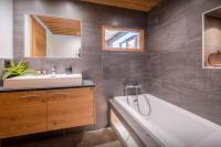 a bathroom with a tub and a sink and a mirror at Chalet 65bis - OVO Network in Thônes