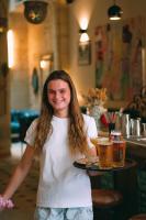 a woman holding a tray of beer on a table at LOLA Boutique Hôtel - Bordeaux Centre in Bordeaux