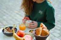 a woman sitting at a table with a tray of breakfast food at LOLA Boutique Hôtel - Bordeaux Centre in Bordeaux