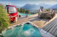 a backyard deck with a hot tub and a rv at Chalet Kalyssia - OVO Network in Saint-Jorioz