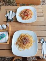 アドラサンにあるLitost Cafeの木のテーブルの上にパスタの皿が2枚