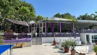 a restaurant with purple tables and chairs in front of a building at Парк-хотел РИВА in Golden Sands