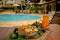 uma tigela de comida e uma bebida numa mesa ao lado de uma piscina em Pousada Una em Barra do Una
