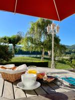una mesa de picnic con un plato de comida y una sombrilla en Hôtel Restaurant du Lac, en Boussens