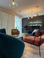Una sala de estar con un sofá y sillas y un bar. en Hôtel Restaurant du Lac, en Boussens