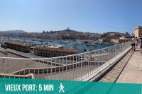 a white pedestrian bridge over a city with a harbor at Le Mucem du Vieux Port in Marseille