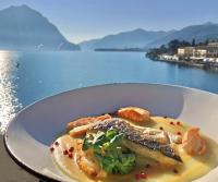 a plate of food with a view of the water at Hotel Lovere Resort & Spa in Lovere
