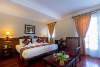 a hotel room with a bed and a table and a window at Victoria Chau Doc Hotel in Chau Doc