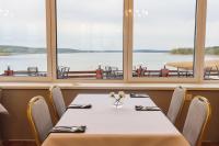 una mesa en un restaurante con vistas al agua en Antonińska Resort SPA, en Boszkowo