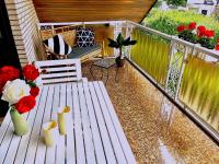 a deck with a bench and flowers on a balcony at VILLA ORCHARD Frankfurt in Zeilsheim