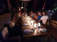 a group of people sitting around a long wooden table at Batuta Maldives Inn in Thulusdhoo