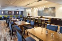 un restaurant avec des tables et des chaises en bois et un bar dans l'établissement DoubleTree by Hilton Neenah, à Neenah