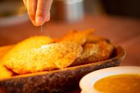 a person is sprinkling sauce on a plate of food at Hotel Tambopaxi in Machachi