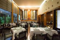 a restaurant with white tables and chairs and windows at King&#39;s Town Hotel in Kaohsiung