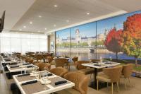um restaurante com mesas e cadeiras e um grande mural em Embassy Suites By Hilton Montreal Airport em Pointe-Claire