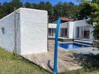 a house with a wooden deck and a swimming pool at La Casba 15 mm plage Contis in Lévignacq