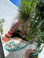 a garden with a green hose next to a staircase at La Casba 15 mm plage Contis in Lévignacq