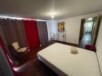 a bedroom with a white bed and red curtains at La Casba 15 mm plage Contis in Lévignacq