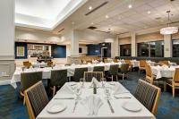 a dining room with white tables and chairs at Hilton Garden Inn Toronto/Mississauga in Mississauga