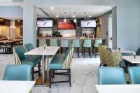 a restaurant with tables and chairs and a bar at Hilton Garden Inn Halifax Airport in Enfield
