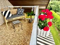 a patio with a bench and red flowers and a chair at VILLA ORCHARD Frankfurt in Zeilsheim