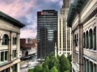 Un edificio alto con un cartel en una ciudad. en The Hilton Garden Inn Buffalo-Downtown, en Buffalo