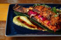 ein blauer Teller mit einem Sandwich und einer Gewürzgurke in der Unterkunft The Waterfront Beach Resort, A Hilton Hotel in Huntington Beach