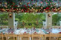 a long table with chairs and flowers hanging from a ceiling at Binh An Village Resort in Da Lat