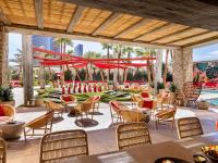 eine Terrasse in einem Resort mit Tischen und Stühlen in der Unterkunft Crockfords Las Vegas, LXR Hotels &amp; Resorts at Resorts World in Las Vegas