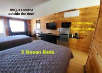 a hotel room with two beds and a desk at Boardwalk Motel in Cavendish