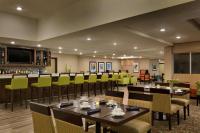 a restaurant with tables and chairs and a bar at Hilton Garden Inn Statesville in Statesville