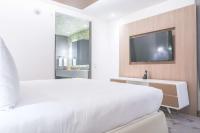 a white bedroom with a large bed and a tv at Gran Hotel Costa Rica, Curio Collection By Hilton in San José