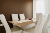 a dining room with a table and white chairs at Apartman Stil in Bugojno