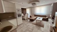 a kitchen and living room with a couch and a table at Apartman Stil in Bugojno