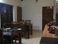 Un comedor con mesas y sillas de madera. en Alfred Place, en Kochi