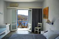 a bedroom with a bed and a balcony with a table at Patmos Paradise Hotel in Kámbos