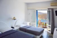 a hotel room with two beds and a balcony at Patmos Paradise Hotel in Kámbos