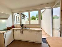 a kitchen with white cabinets and a sink and windows at Suite Clovis 2 in Reims