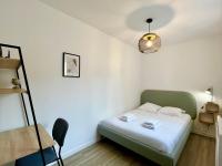 a small bedroom with a bed and a lamp at Suite Clovis 2 in Reims