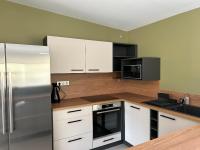 a kitchen with white cabinets and a stainless steel refrigerator at Sol&#39;m Lodges in Solesmes