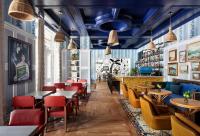 ein Restaurant mit blauen Decken, Tischen und Stühlen in der Unterkunft Graduate by Hilton Chapel Hill in Chapel Hill