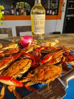 Un plato de cangrejos en una mesa con una botella de vino. en Eco-Hotel Chevere Beach, en Puebloviejo